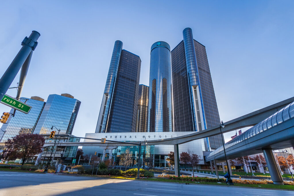 The renaissance center, headquarters of general motors in detroit, with its distinctive cylindrical towers against a clear blue sky.