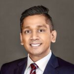 Professional headshot of Abhi Nemani in a suit and tie.