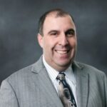 Professional headshot of Jeff Goldstein in a gray suit.