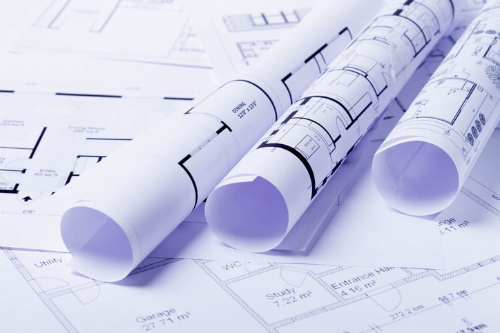 Blue prints rolled up on a desk as a guide for where to place a Euna Payments Utility bill payment kiosk